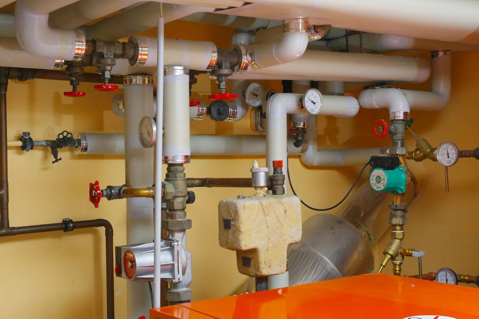 Neu verlegte Wasser- und Heizungsrohre mit Ventilen in einem Technikraum
